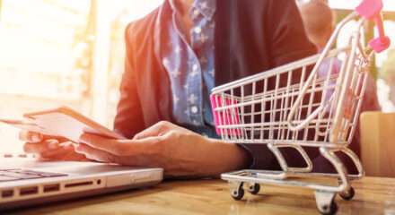 Cropped image of woman inputting card information and key on phone or laptop while shopping online